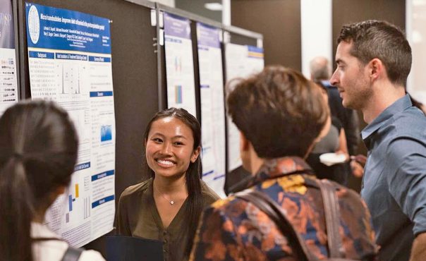 students gathered before presentation posters on Translational Science Research Day 2019